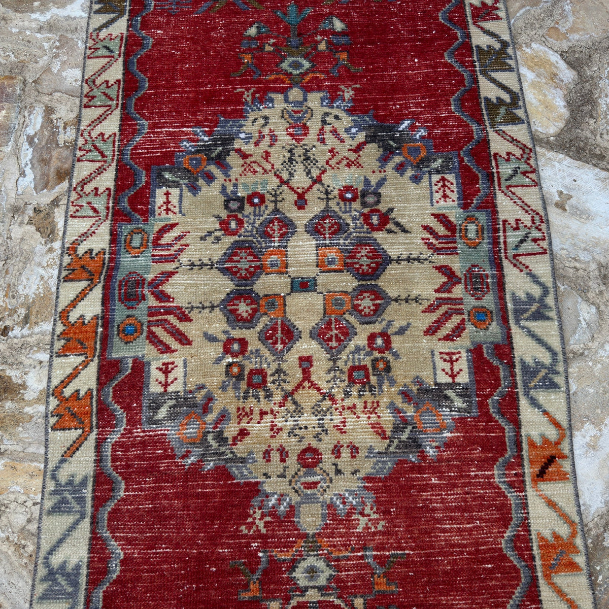 Red 2' x 5' vintage Turkish traditional rug in wool and cotton, shown on the floor.