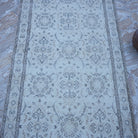 Close-up of the beige vintage Turkish traditional rug showing traditional details, hand-knotted weave, wool and cotton and low pile.
