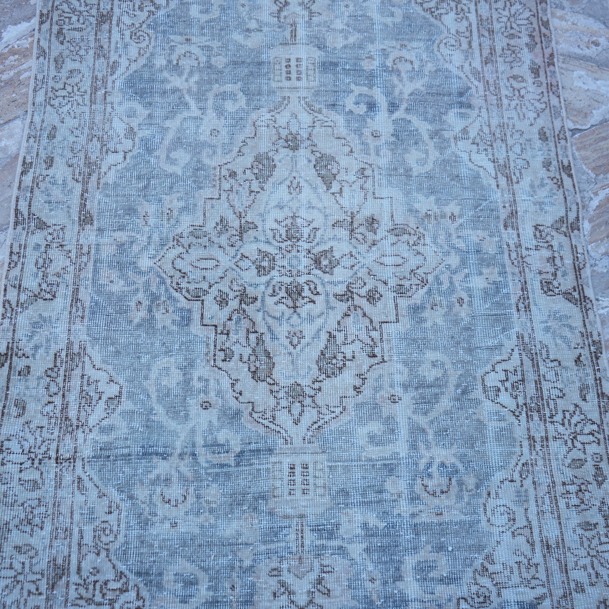 Close-up of the blue vintage Turkish traditional rug showing traditional details, hand-knotted weave, wool and cotton and low pile.