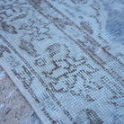 Blue 4' x 7' vintage Turkish traditional rug in wool and cotton, shown on the floor.
