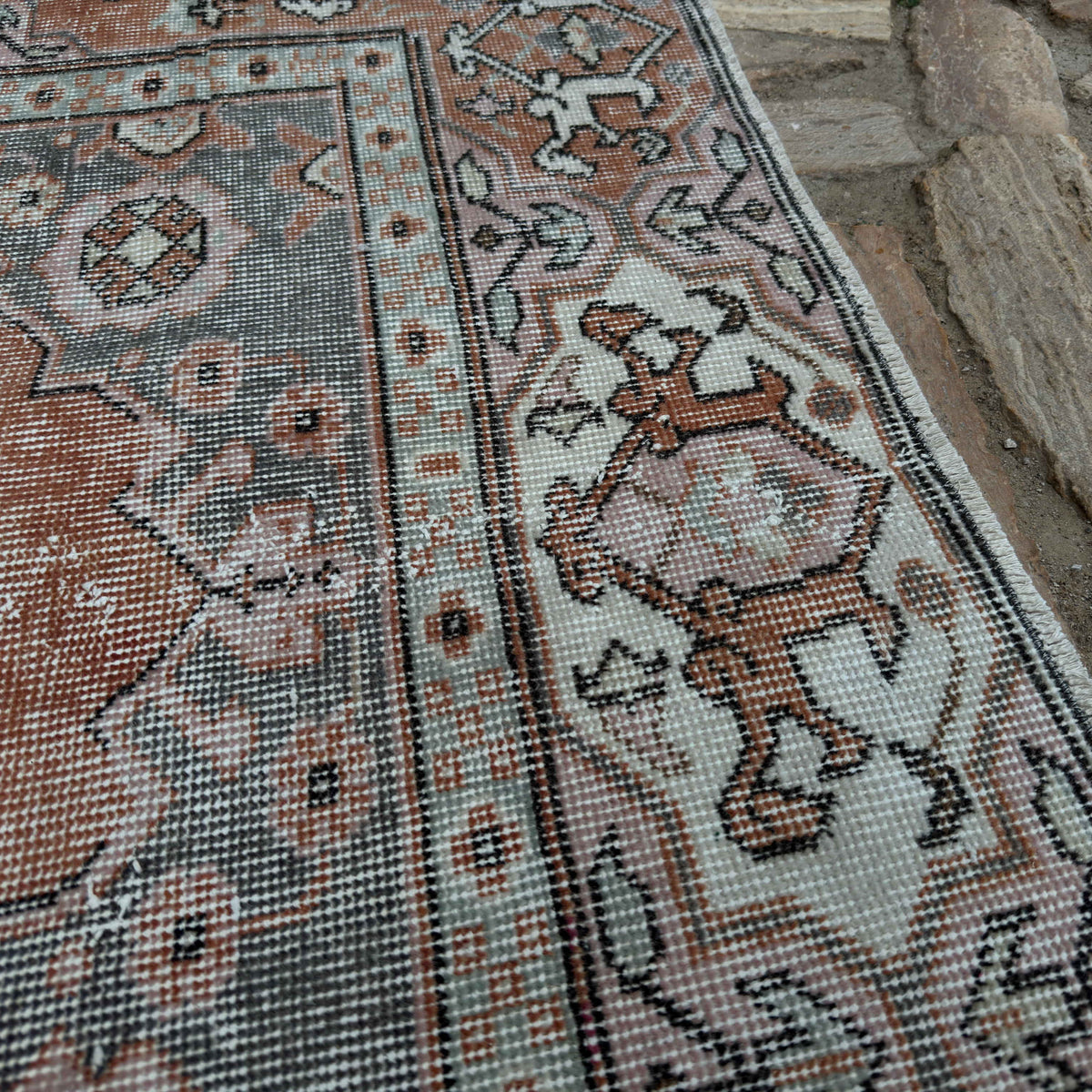 Close-up of the pale orange vintage Turkish traditional rug showing medallion details, hand-knotted weave, wool and cotton and low pile.