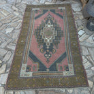 Pale Red 4' x 7' vintage Turkish traditional rug in wool and cotton, shown on the floor.