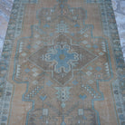 Close-up of the orange vintage Turkish traditional rug showing traditional details, hand-knotted weave, wool and cotton and low pile.