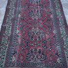 Close-up of the red vintage Turkish traditional rug showing traditional details, hand-knotted weave, wool and cotton and low pile.