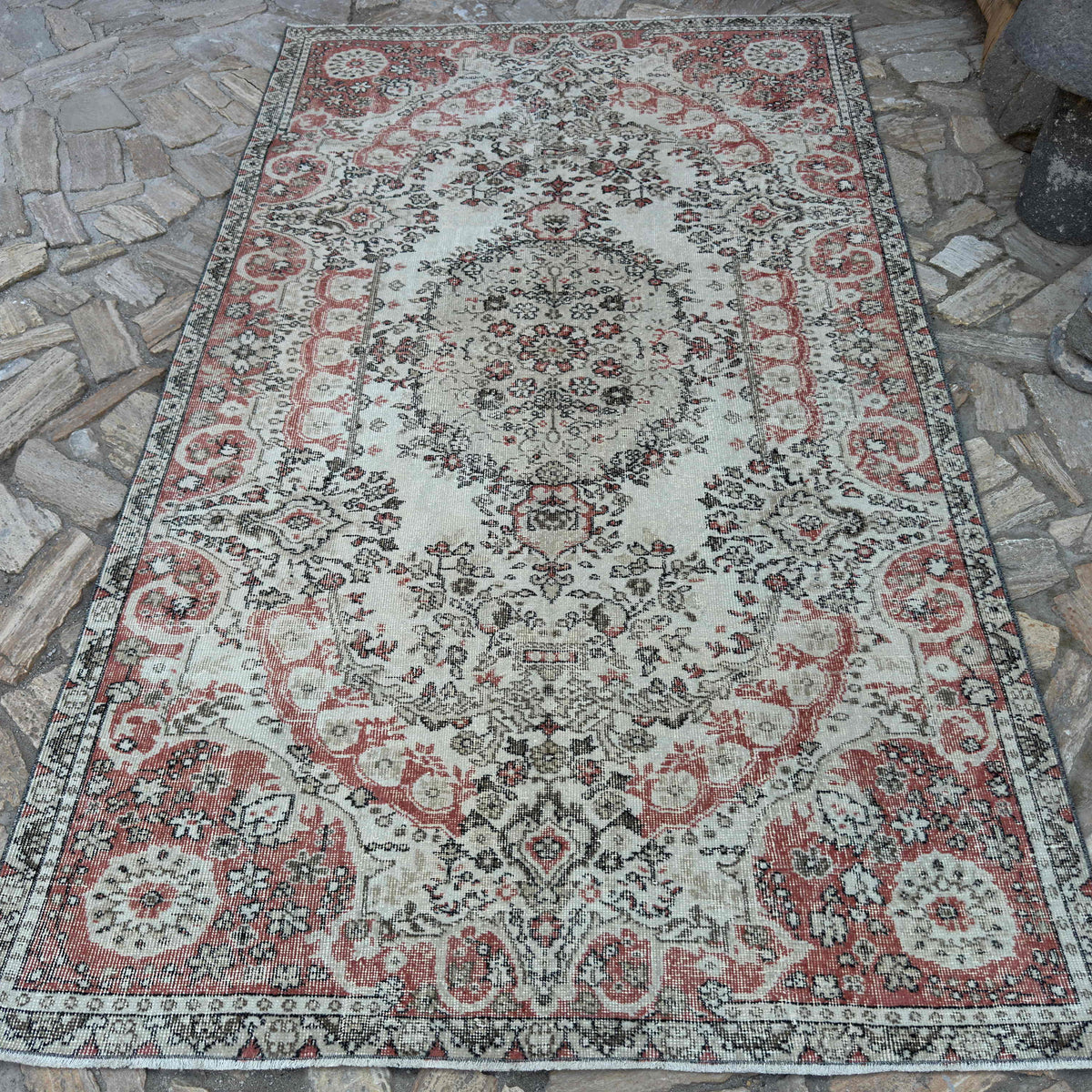 Pale Red 5' x 9' vintage Turkish traditional rug in wool and cotton, shown on the floor.