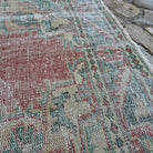 Close-up of the pink vintage Turkish traditional rug showing medallion details, hand-knotted weave, wool and cotton and low pile.