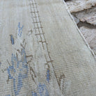 Close-up of the beige vintage Turkish traditional rug showing traditional details, hand-knotted weave, wool and cotton and low pile.