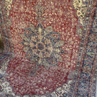 Red 7' x 10' vintage Turkish traditional rug in wool and cotton, shown on the floor.
