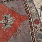 Close-up of the red vintage Turkish traditional runner rug showing medallion details, hand-knotted weave, wool and cotton and low pile.