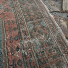 Close-up of the pale red vintage Turkish traditional runner rug showing traditional details, hand-knotted weave, wool and cotton and low pile.