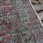 Close-up of the red vintage Turkish traditonal rug showing floral details, hand-knotted weave, wool and cotton and low pile.