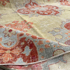 Close-up of the yellow vintage turkish area rug showing floral details, hand-knotted weave, wool and cotton and low pile.