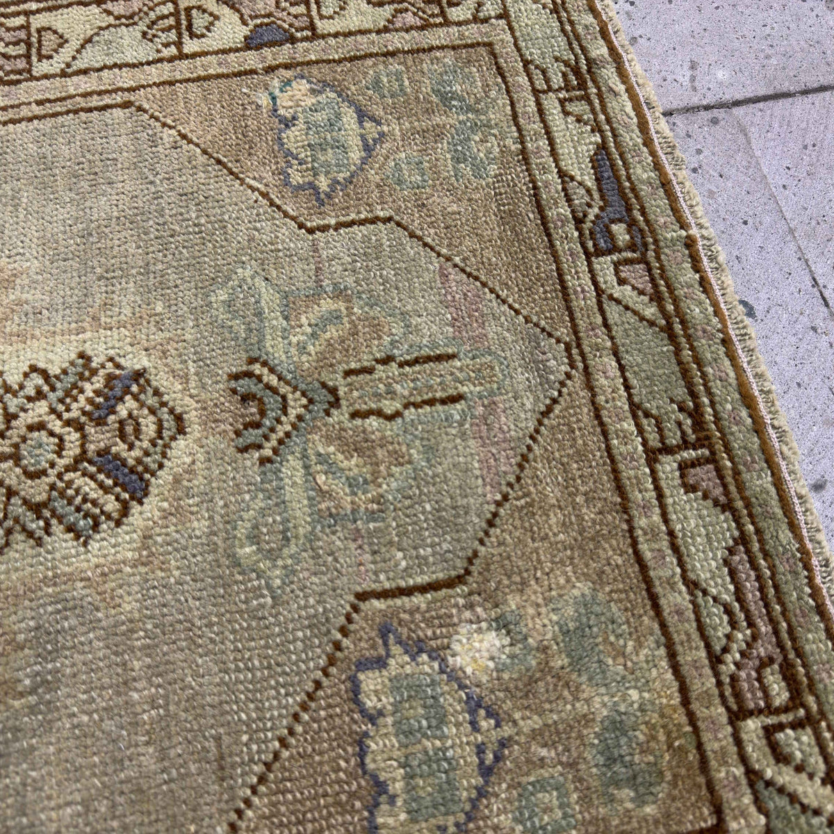 Close-up of the red vintage turkish carpet showing traditional and neutral details, hand-knotted weave, wool and cotton and low pile.