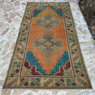 Orange 4' x 8' vintage turkish carpet in wool and cotton, shown on the floor.