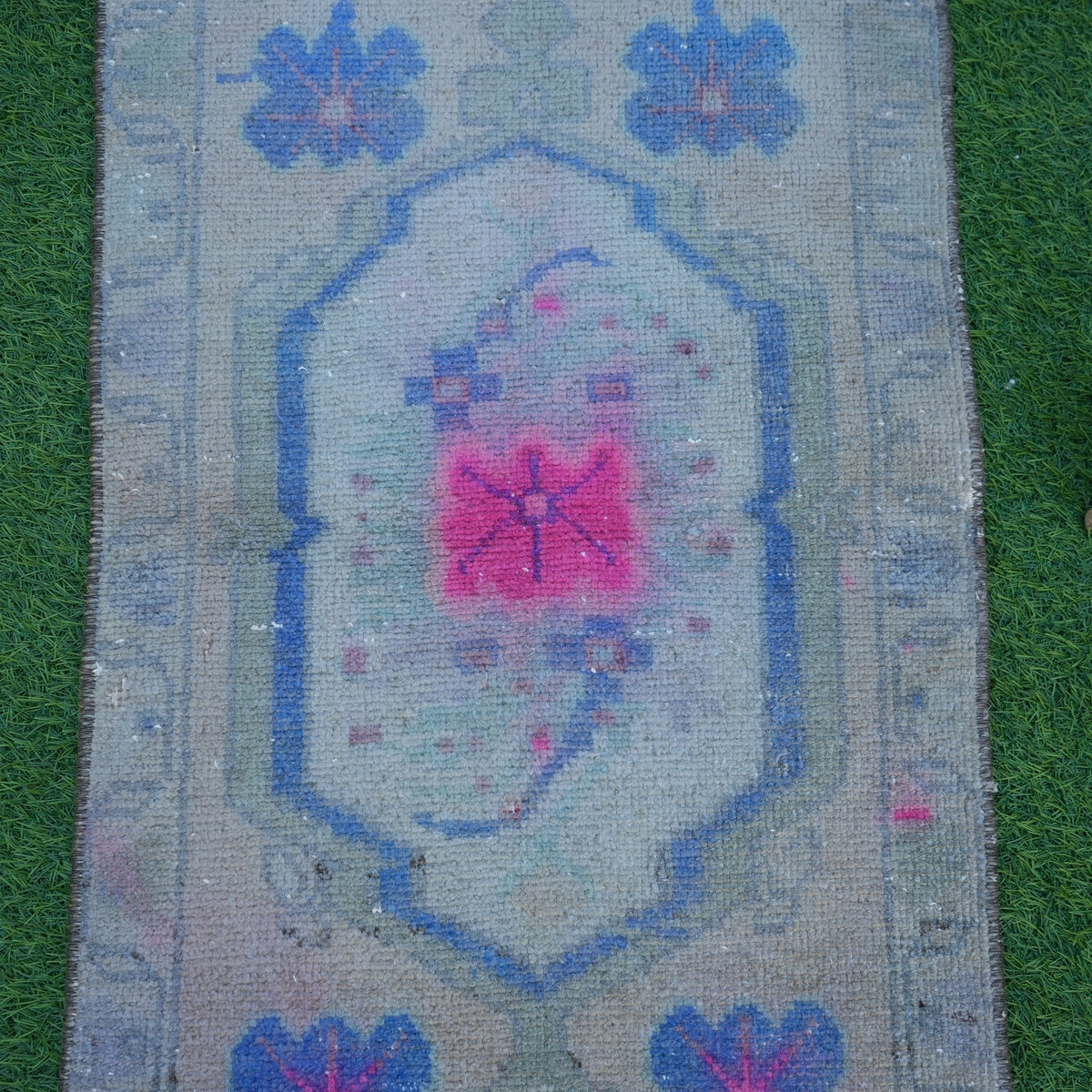 Close-up of the beige vintage turkish rug showing traditional details, hand-knotted weave, wool and cotton and low pile.