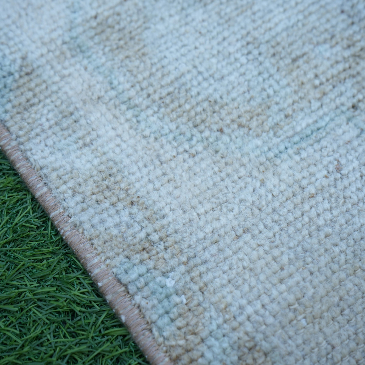 Beige 1' x 3' vintage turkish rug in wool and cotton, shown on the floor.