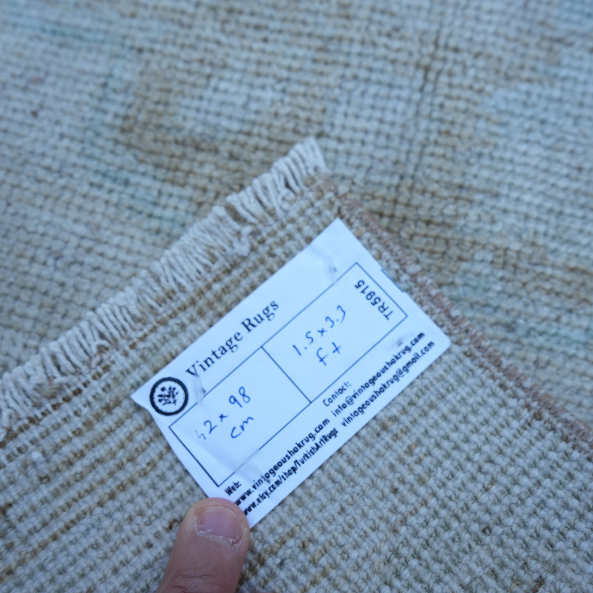 Beige 1' x 3' vintage turkish rug from the 1970s with neutral design.