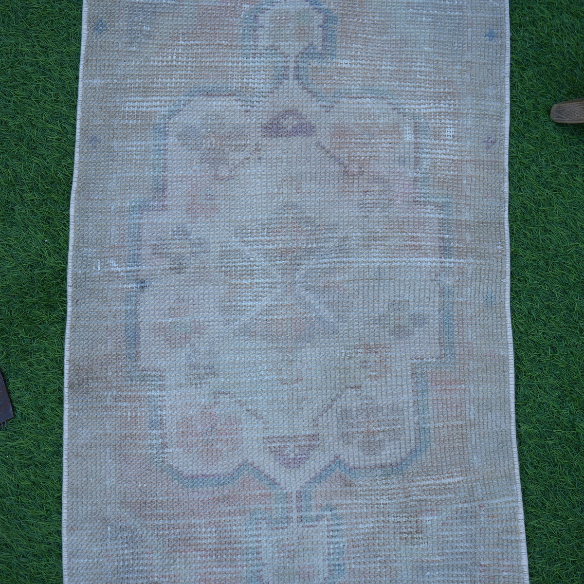 Close-up of the beige vintage turkish rug showing neutral details, hand-knotted weave, wool and cotton and low pile.