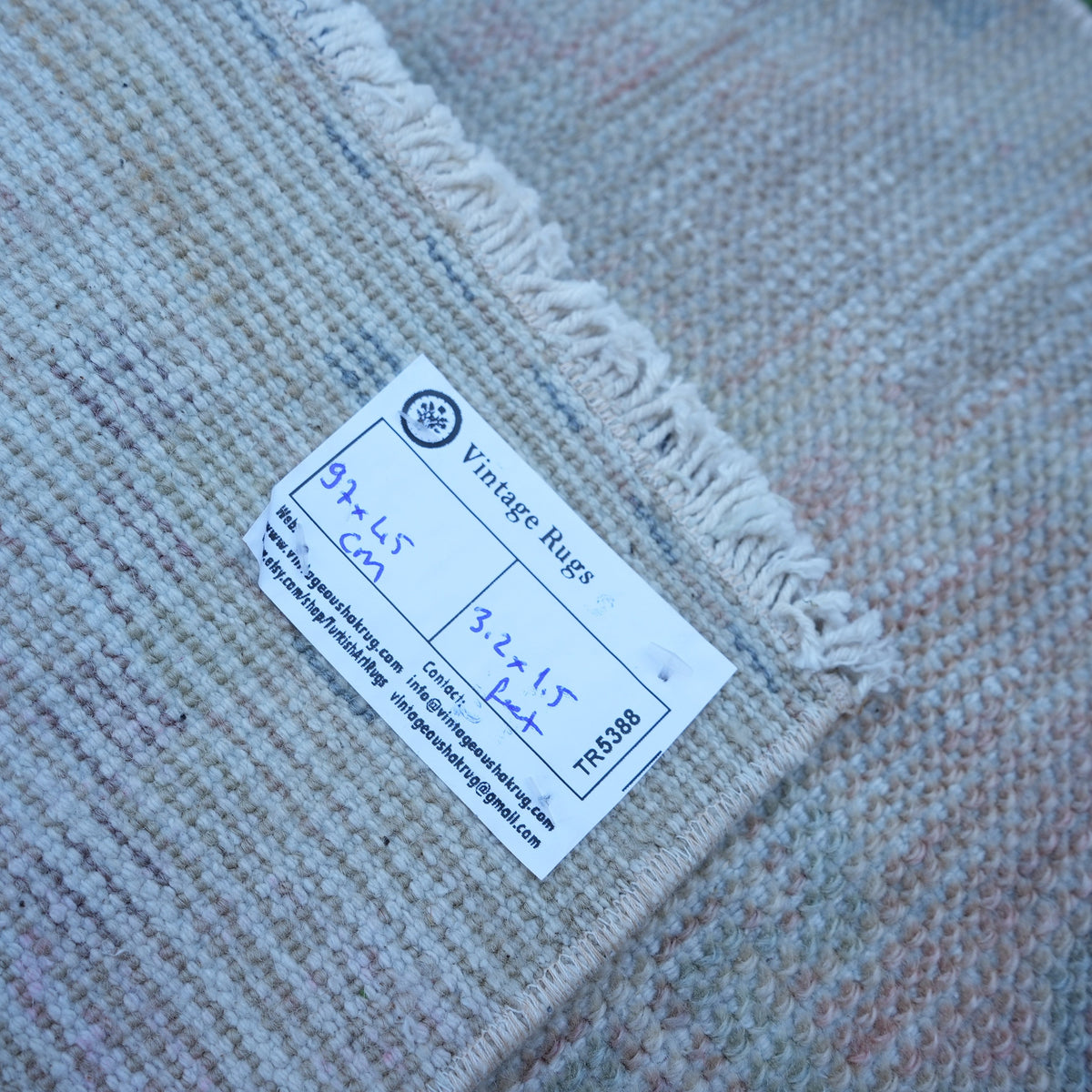 Beige 1' x 3' vintage turkish rug from the 1970s with neutral design.
