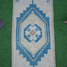 Close-up of the blue vintage turkish rug showing geometric details, hand-knotted weave, wool and cotton and low pile.