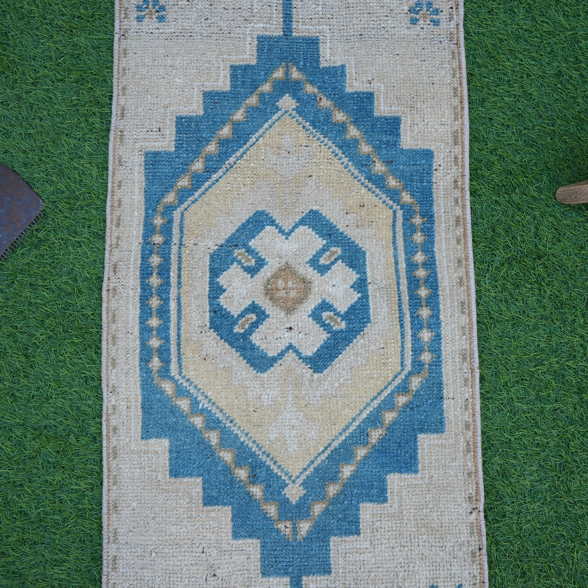Close-up of the blue vintage turkish rug showing geometric details, hand-knotted weave, wool and cotton and low pile.