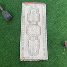 Brown 1' x 3' vintage turkish rug in wool and cotton, shown on the floor.