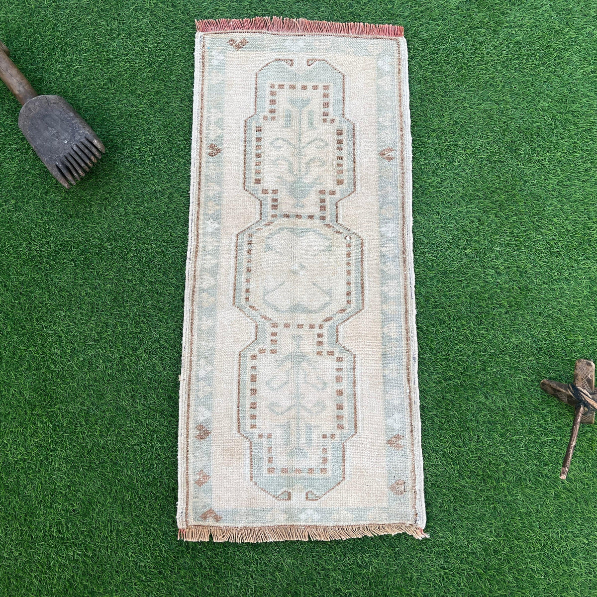 Brown 1' x 3' vintage turkish rug in wool and cotton, shown on the floor.