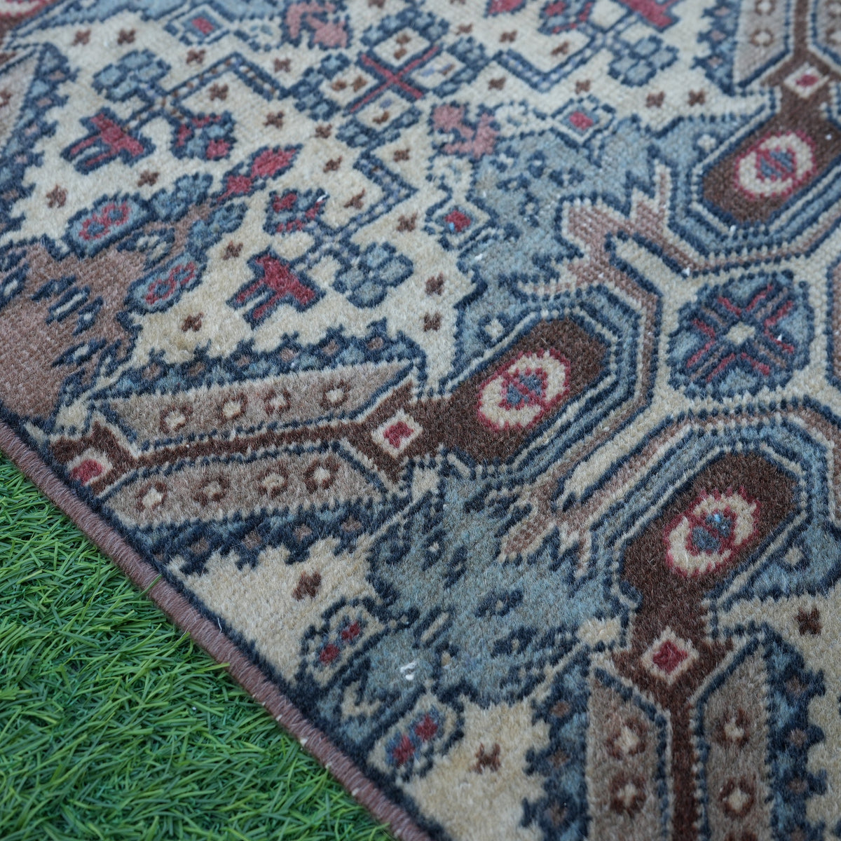 Brown 1' x 3' vintage turkish rug in wool and cotton, shown on the floor.