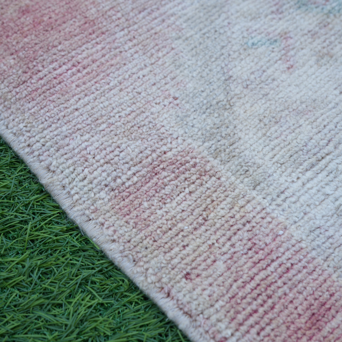 Pale Red 1' x 3' vintage turkish rug in wool and cotton, shown on the floor.