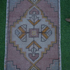 Close-up of the pink vintage turkish rug showing traditional details, hand-knotted weave, wool and cotton and low pile.