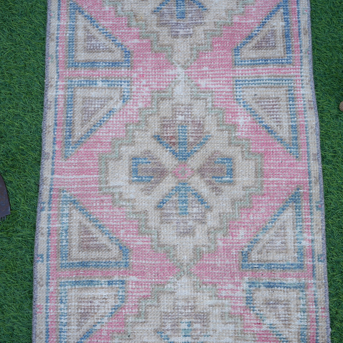 Close-up of the pink vintage turkish rug showing traditional details, hand-knotted weave, wool and cotton and low pile.