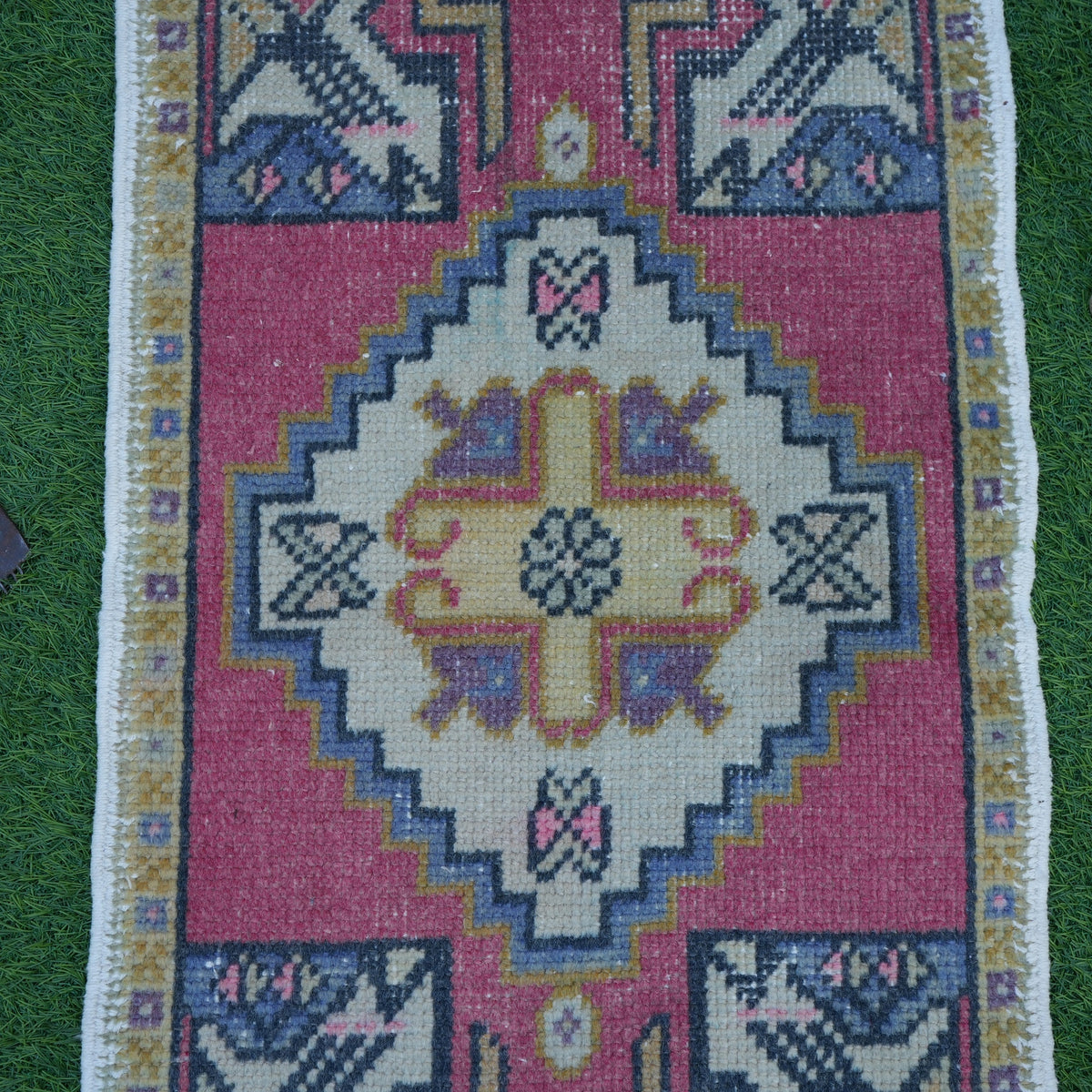 Close-up of the red vintage turkish rug showing traditional details, hand-knotted weave, wool and cotton and low pile.
