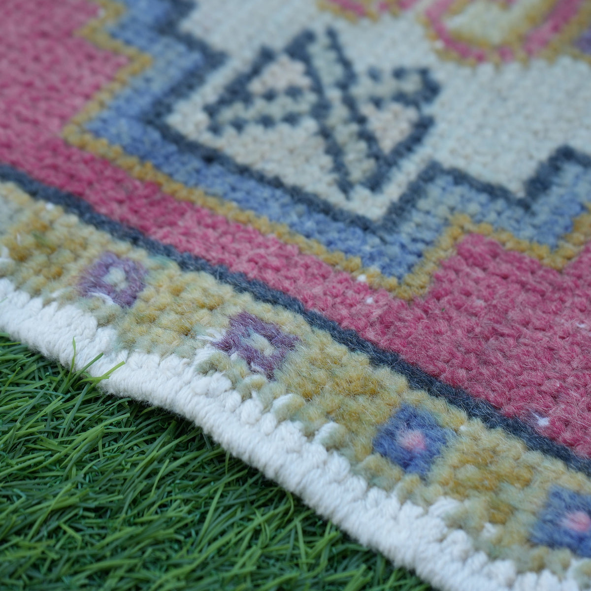 Red 1' x 3' vintage turkish rug in wool and cotton, shown on the floor.