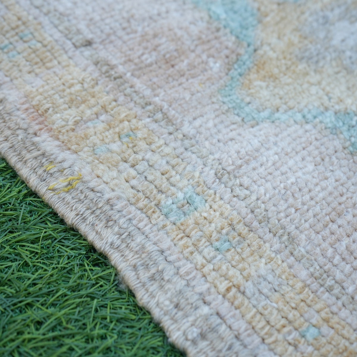 Beige 2' x 2' vintage turkish rug in wool and cotton, shown on the floor.