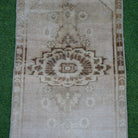 Close-up of the beige vintage turkish rug showing neutral details, hand-knotted weave, wool and cotton and low pile.