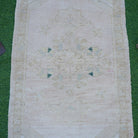 Close-up of the beige vintage turkish rug showing neutral details, hand-knotted weave, wool and cotton and low pile.