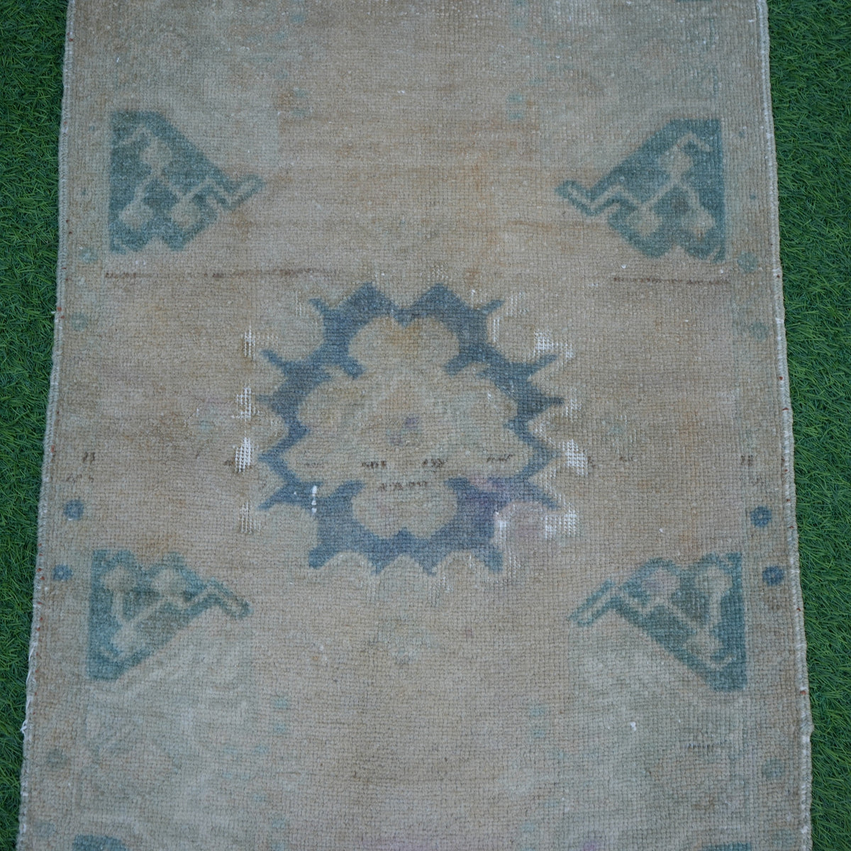 Close-up of the beige vintage turkish rug showing neutral details, hand-knotted weave, wool and cotton and low pile.