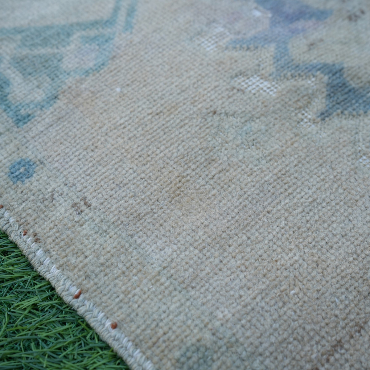 Beige 2' x 3' vintage turkish rug in wool and cotton, shown on the floor.