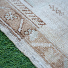 Brown 2' x 3' vintage turkish rug in wool and cotton, shown on the floor.