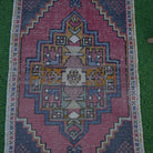 Close-up of the pale red vintage turkish rug showing traditional details, hand-knotted weave, wool and cotton and low pile.
