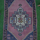 Close-up of the pink vintage turkish rug showing traditional details, hand-knotted weave, wool and cotton and low pile.
