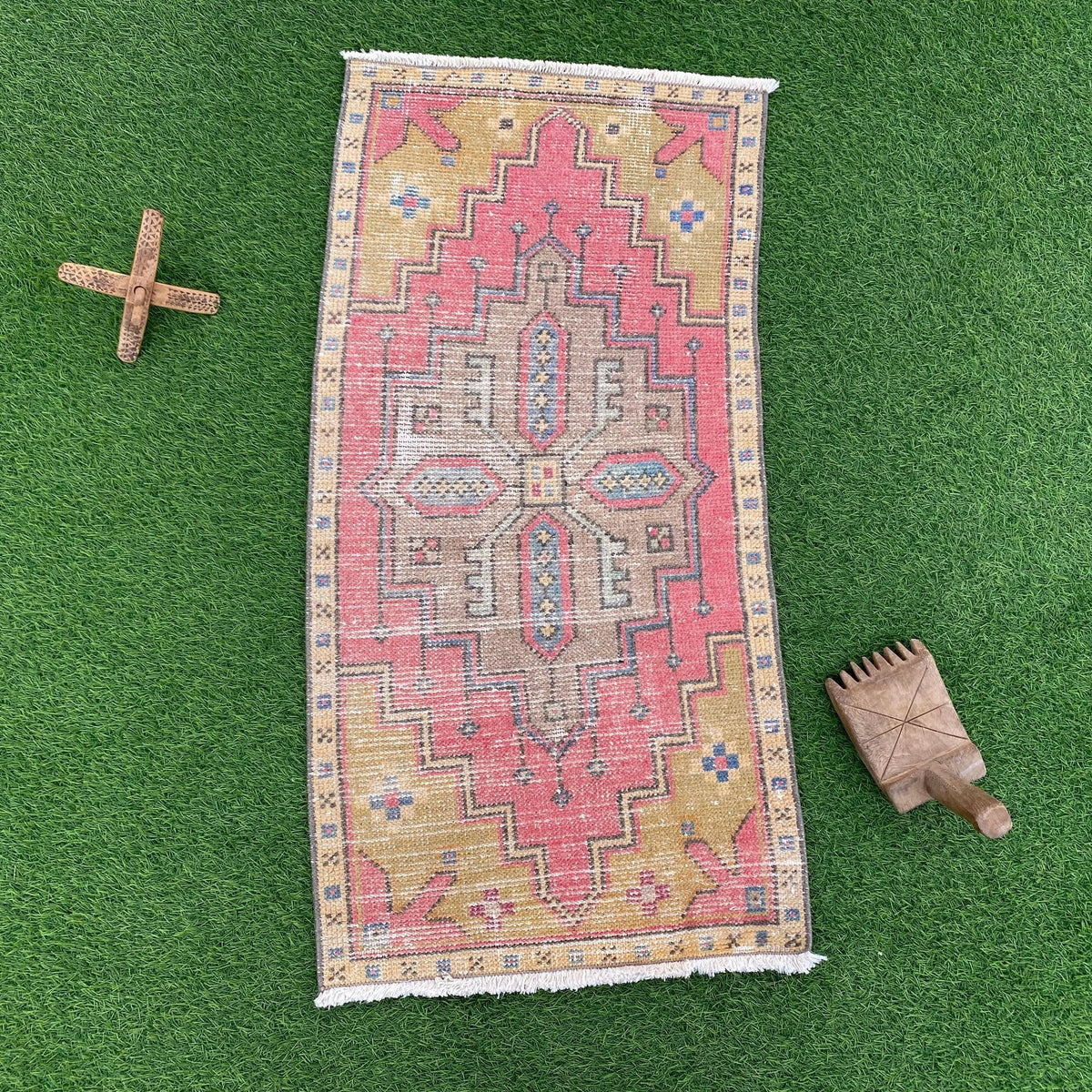 Pink 2' x 3' vintage turkish rug in wool and cotton, shown on the floor.