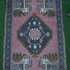 Close-up of the pink vintage turkish rug showing traditional details, hand-knotted weave, wool and cotton and low pile.