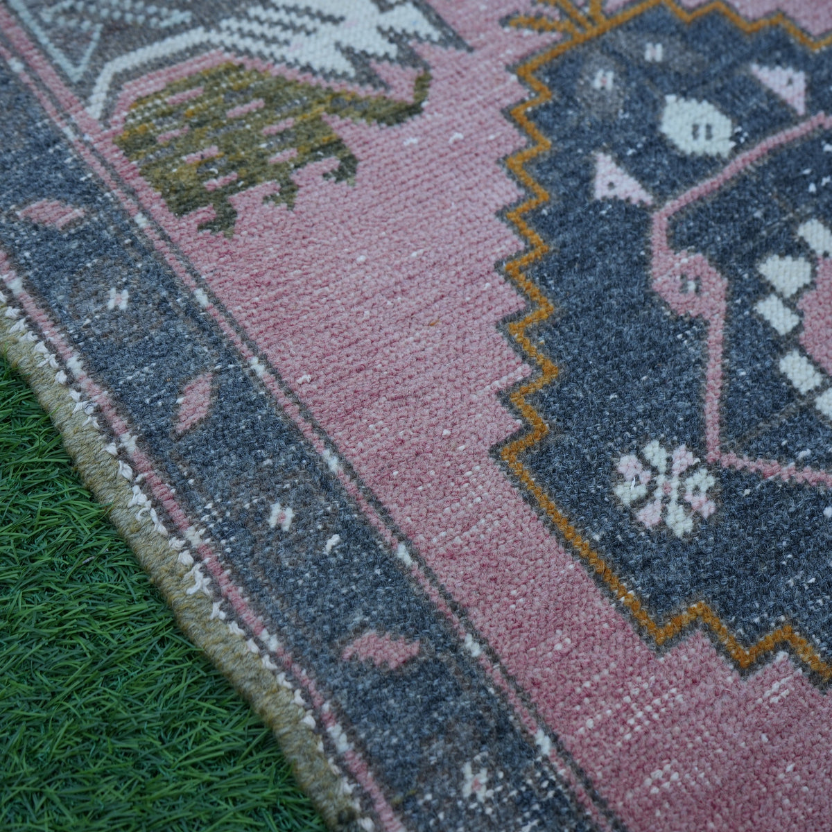 Pink 2' x 3' vintage turkish rug in wool and cotton, shown on the floor.