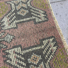 Close-up of the pink vintage turkish rug showing traditional details, hand-knotted weave, wool and cotton and low pile.