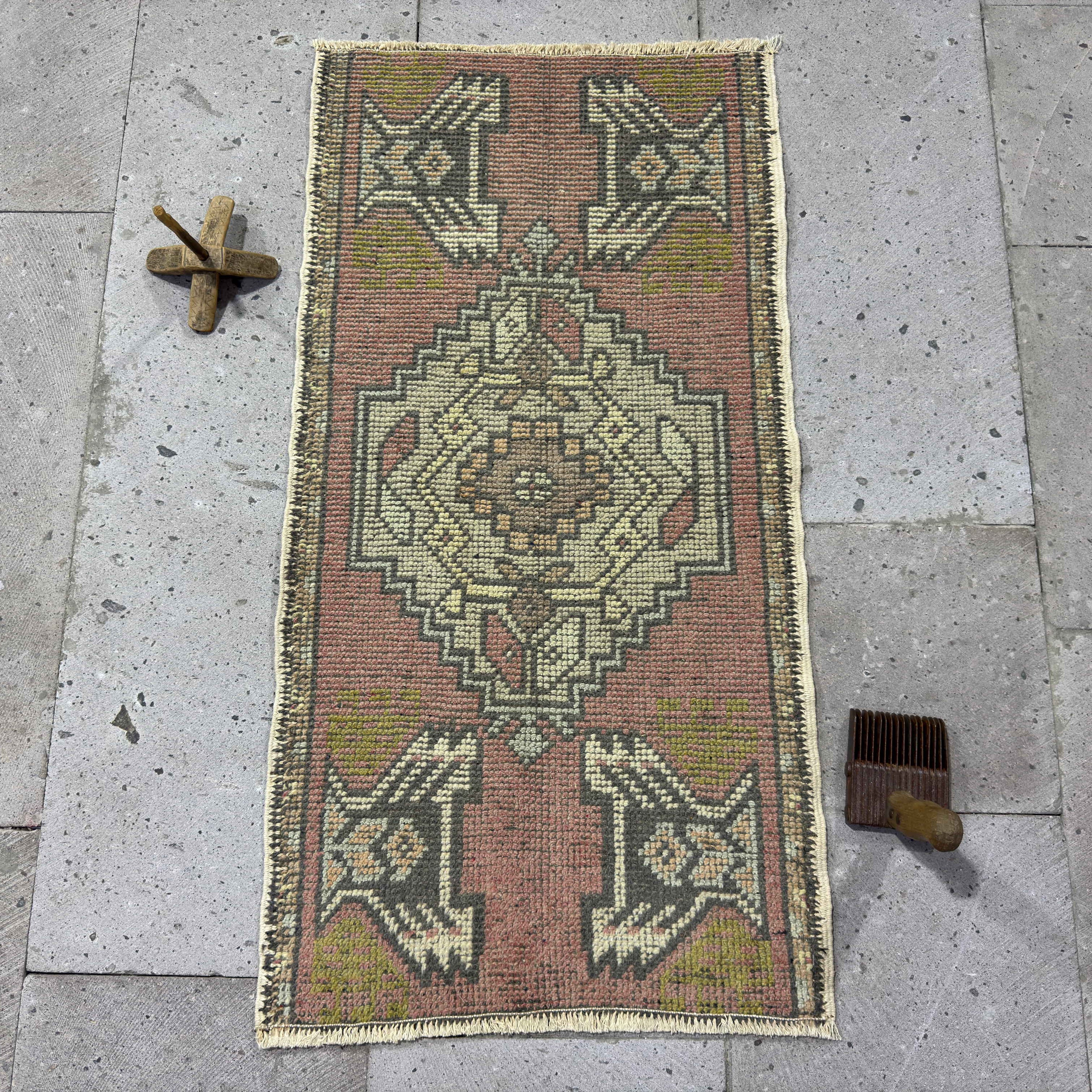 Pink 2' x 3' vintage turkish rug in wool and cotton, shown on the floor.