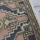 Close-up of the pink vintage turkish rug showing traditional details, hand-knotted weave, wool and cotton and low pile.