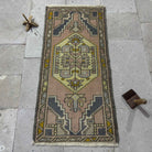 Pink 2' x 3' vintage turkish rug in wool and cotton, shown on the floor.