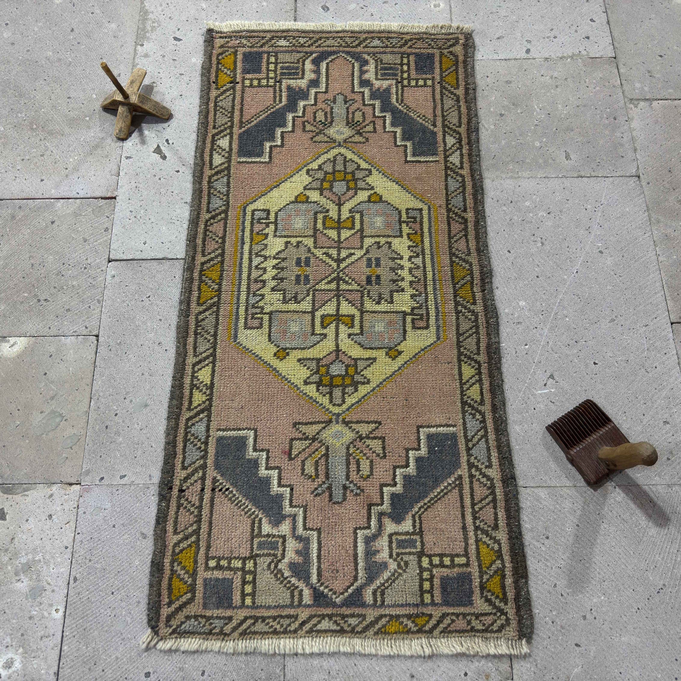 Pink 2' x 3' vintage turkish rug in wool and cotton, shown on the floor.