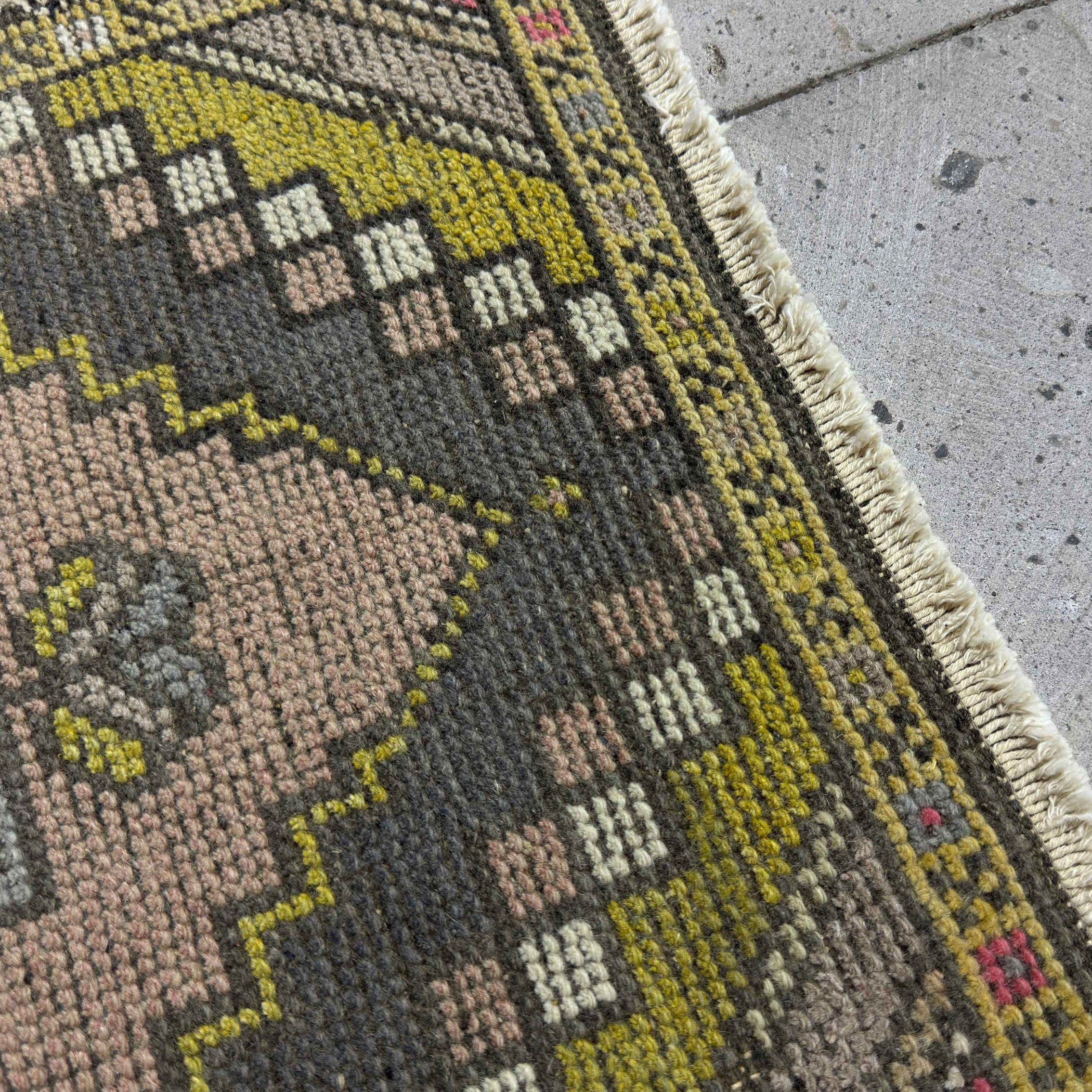 Close-up of the pink vintage turkish rug showing traditional details, hand-knotted weave, wool and cotton and low pile.